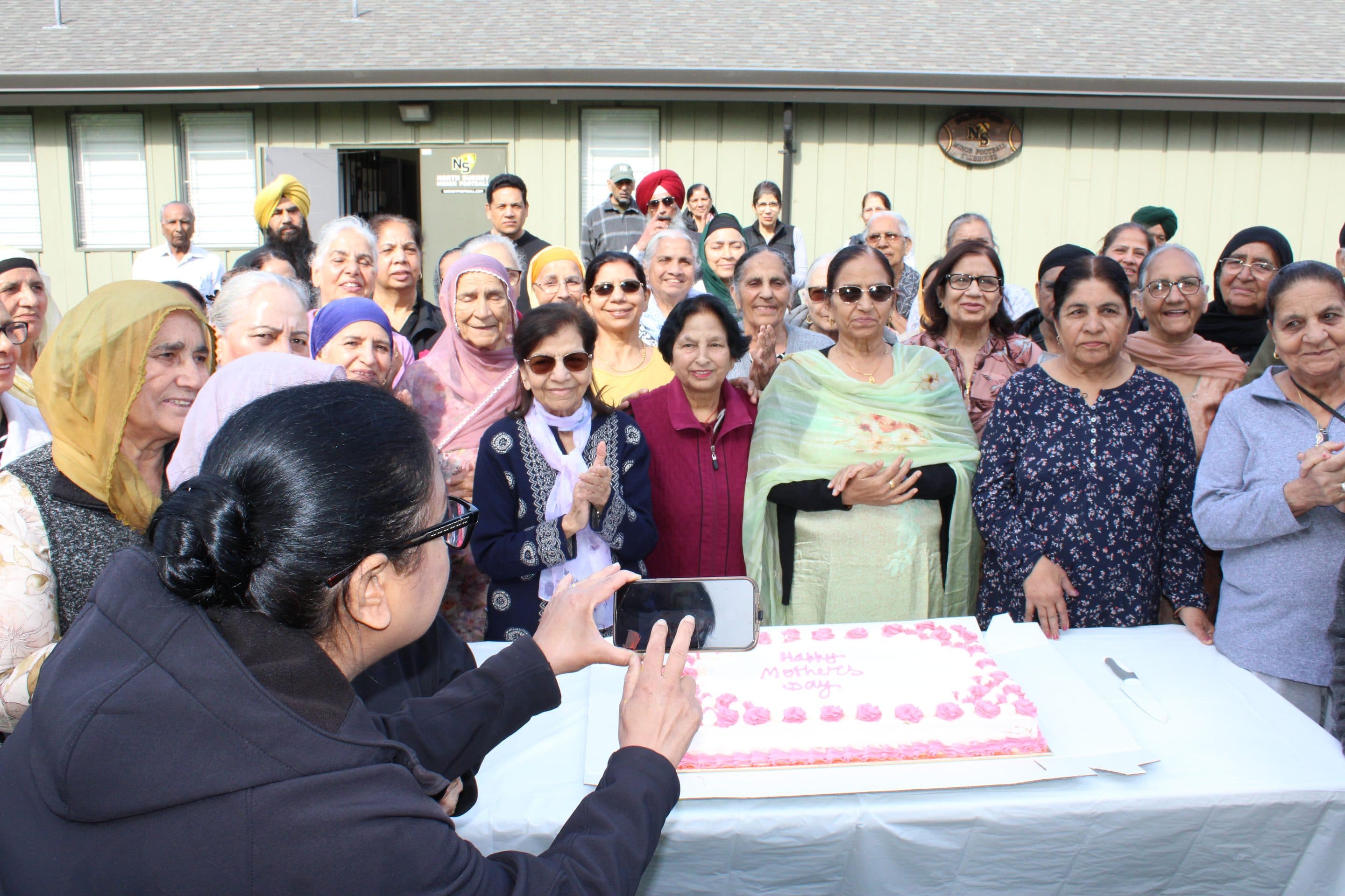 A guest takes a phone photo of the Mother's Day cake.