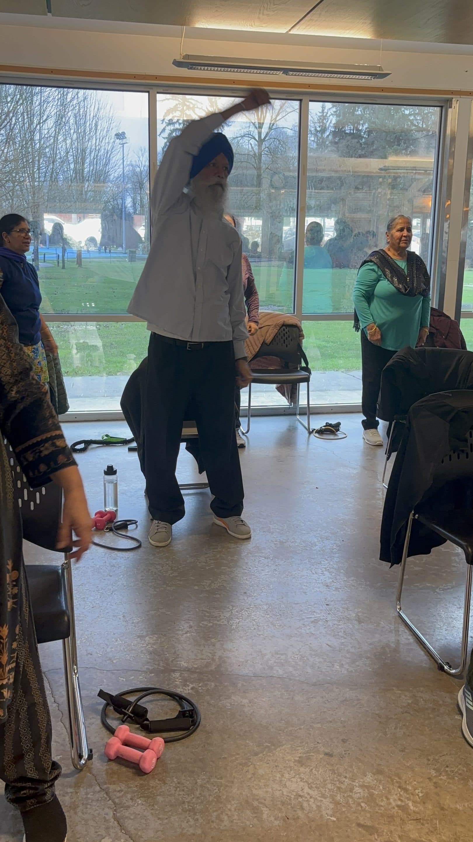 A community member doing a standing side-stretch in class.